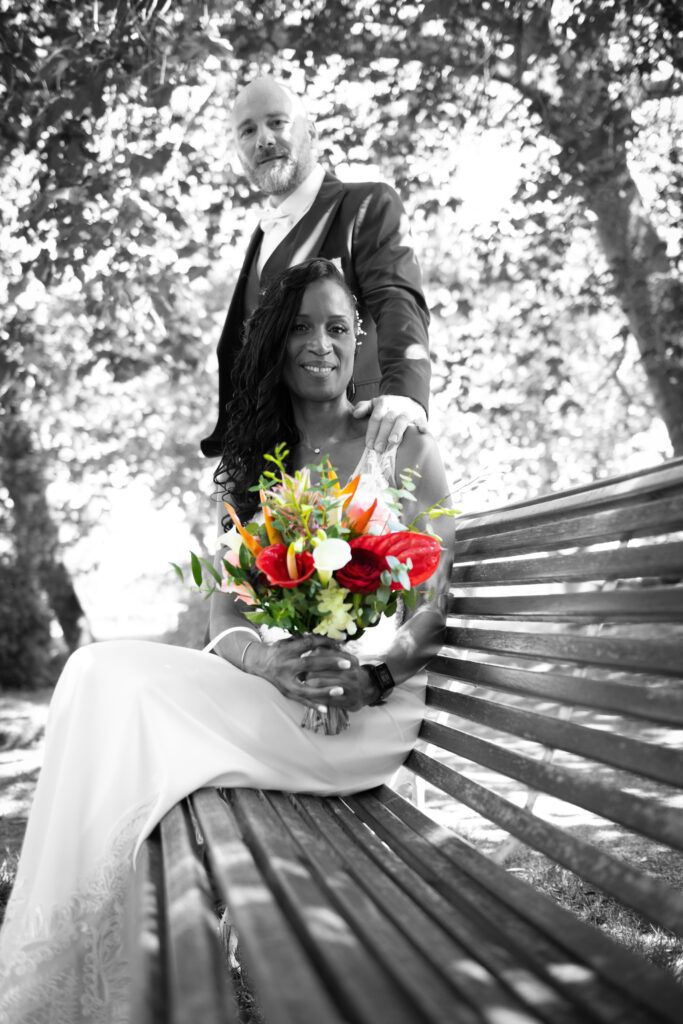 Mariage de Valéry et Olivier au parc des Capucins à Coulommiers, photo lumineuse des mariés posant sur un banc.