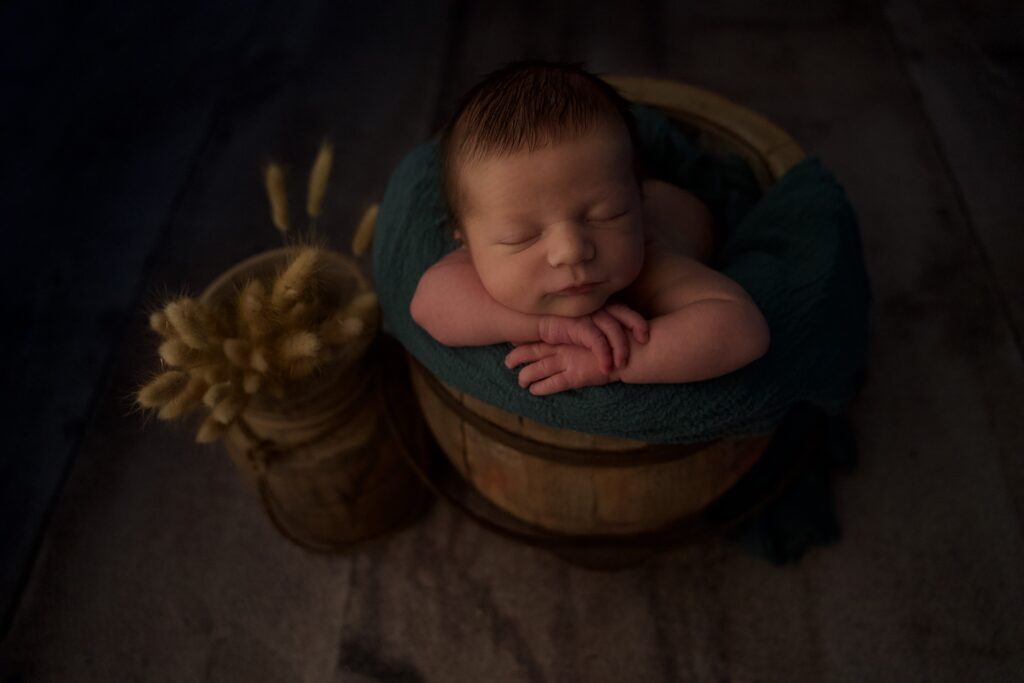 Séance photo naissance de Gabriela au home studio à Meaux, posée dans un tonneau rustique avec un décor champêtre.