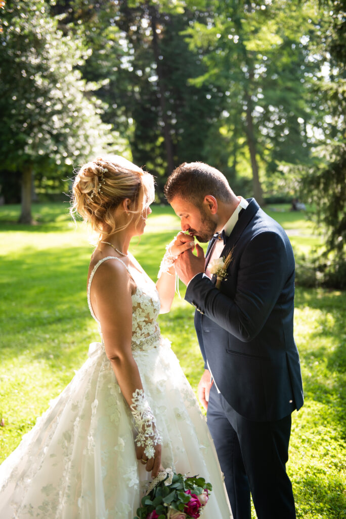 Mariage de Tania et Mickael à La Ferté-sous-Jouarre, Mickael embrassant tendrement la main de Tania dans une lumière naturelle au parc des Capucins.