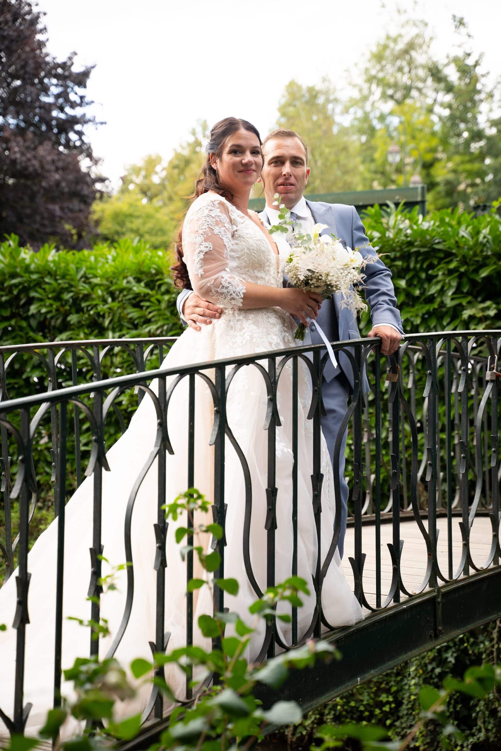 Shirley et Jonathan posant sur le pont du parc des Capucins à Coulommiers avec un bouquet de mariée, immortalisés par Arnaud-M Photographe lors du mariage de Shirley et Jonathan à Coulommiers.